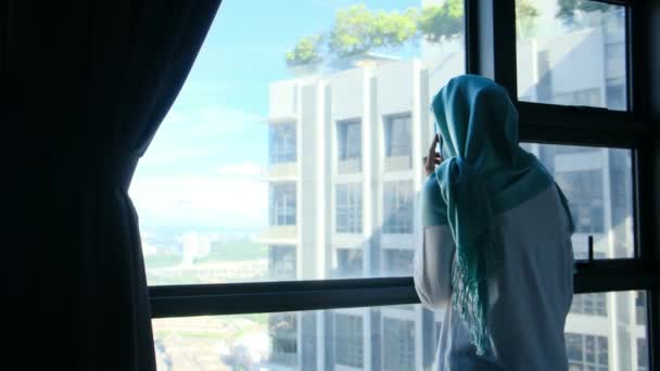 Mulher Muçulmana Atraente Hijab Usando Telefone Celular Perto Janela — Vídeo de Stock
