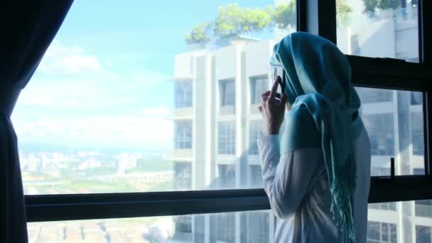 Vonzó Muszlim Hidzsáb Használja Mobiltelefon Közel Ablakhoz — Stock videók
