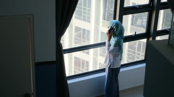 Atraktivní Muslimka Hidžábu Pomocí Mobilního Telefonu Blízkosti Okna — Stock video