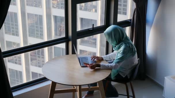 Attraente Donna Musulmana Hijab Utilizzando Computer Portatile Vicino Alla Finestra — Video Stock