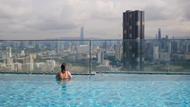 Подорожі Жінка Плаває Даху Нескінченний Басейн Над Міським Краєвидом — стокове відео
