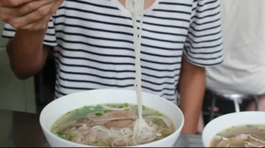 Restorandaki masada Asya yemeği yiyen kadın turistin yakın plan görüntüsü..