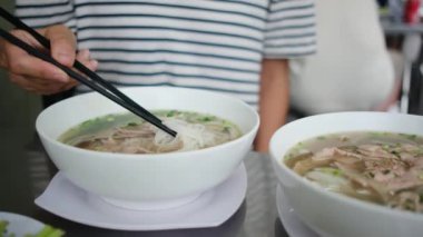 Restorandaki masada Asya yemeği yiyen kadın turistin yakın plan görüntüsü..