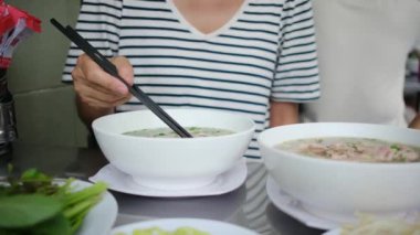 Restorandaki masada Asya yemeği yiyen kadın turistin yakın plan görüntüsü..