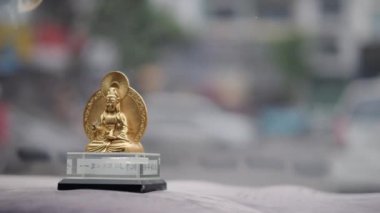 Bulanık yoldaki arabada Buda heykeli