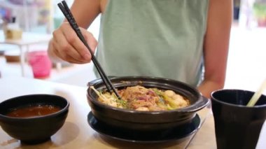 Restorandaki masada Asya yemeği yiyen kadın turistin yakın plan görüntüsü..
