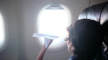 Arka plan, uçaktaki çocuklar pencereden dışarı bakar ve kağıt uçakla oynarlar. Çocuk, gökyüzüne bakıp uçağın kağıt oyuncağıyla oynarken pilot olarak çalışmayı hayal ediyor.. 