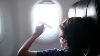 Arka plan, uçaktaki çocuklar pencereden dışarı bakar ve kağıt uçakla oynarlar. Çocuk, gökyüzüne bakıp uçağın kağıt oyuncağıyla oynarken pilot olarak çalışmayı hayal ediyor.. 