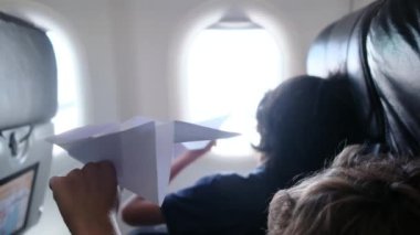 Arka plan, uçaktaki çocuklar pencereden dışarı bakar ve kağıt uçakla oynarlar. Çocuk, gökyüzüne bakıp uçağın kağıt oyuncağıyla oynarken pilot olarak çalışmayı hayal ediyor.. 