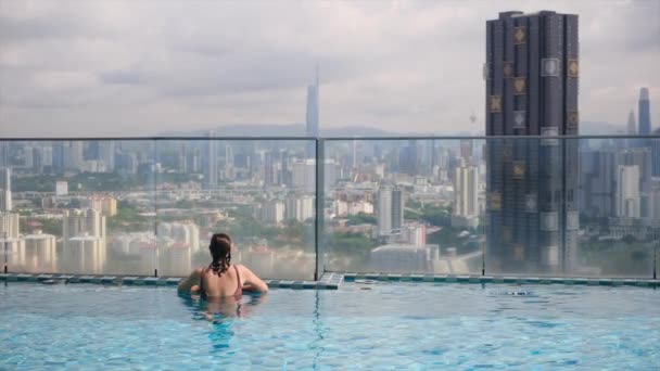 Reisefrau Schwimmt Infinity Pool Auf Dem Dach Über Der Skyline — Stockvideo
