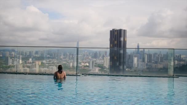 Reisefrau Schwimmt Infinity Pool Auf Dem Dach Über Der Skyline — Stockvideo
