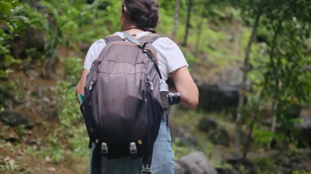 熱帯の山でハイキングを旅行バックパックで帽子で女性の観光客 — ストック動画