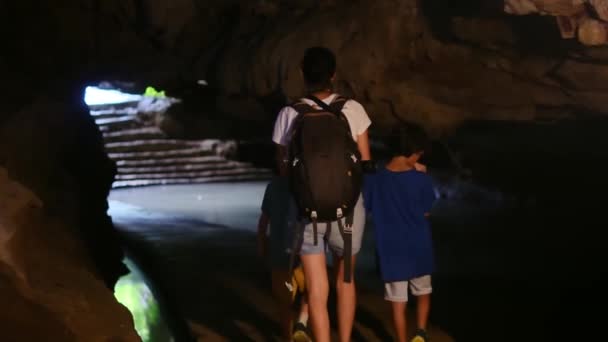 子供と洞窟を歩き回るバックパックを持つ母親 — ストック動画