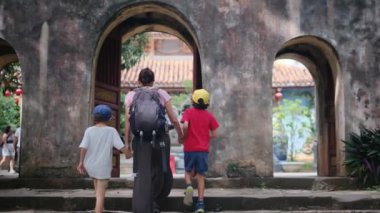 Anne ve oğulları tapınakta yürüyorlar. 