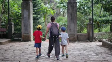 Anne ve oğulları tapınakta yürüyorlar. 