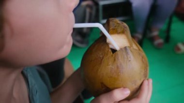 Hindistan cevizi sütü içen tatlı çocuk. 