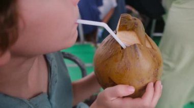 Hindistan cevizi sütü içen tatlı çocuk. 