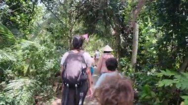 Çocuklu bir kadın, Güneydoğu Asya mirasına tapınağından giriyor.