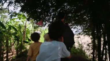 Çocuklu bir kadın, Güneydoğu Asya mirasına tapınağından giriyor.