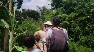Çocuklu bir kadın, Güneydoğu Asya mirasına tapınağından giriyor.
