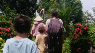 Çocuklu bir kadın, Güneydoğu Asya mirasına tapınağından giriyor.