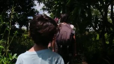 Çocuklu bir kadın, Güneydoğu Asya mirasına tapınağından giriyor.