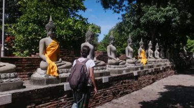 Sırt çantalı bir kadın Güneydoğu Asya tapınağında yürüyor.