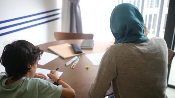 집에서 과업을 아이들을 안내하는 히잡에서 무슬림 어머니를 목격하고 가족을 혼합하십시오 — 비디오