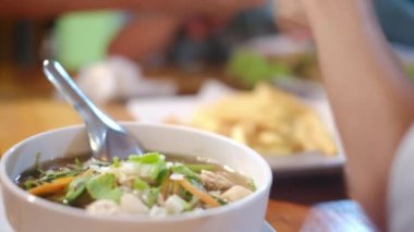 Gezgin Asyalı kadın geleneksel sokak yemekleri alışverişini ve yemeyi seviyor.. 