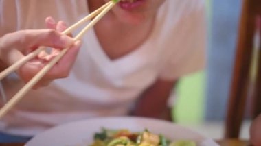 Gezgin Asyalı kadın geleneksel sokak yemekleri alışverişini ve yemeyi seviyor.. 