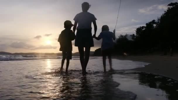 Madre Hijos Caminando Playa Del Océano Bajo Atardecer Día Soleado — Vídeo de stock