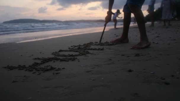 Criança Desenhando Areia Praia Com Pau — Vídeo de Stock