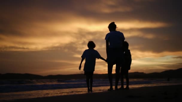 조용한 해변에서 매혹적인 일몰의 배경에 어머니와 그녀의 아들의 실루엣으로 가족의 — 비디오