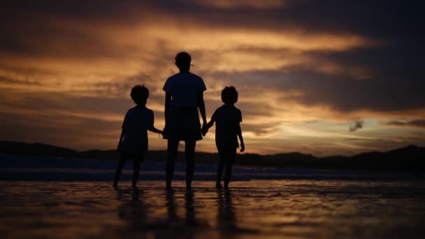 感受家庭联系的温馨本质 就像母亲和儿子们在宁静的海滩上迷人的落日背景下的轮廓 — 图库视频影像