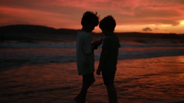 日没のシルエットで海の子供たち 子供たちは太陽に手を差し伸べる キッズドリームコンセプト — ストック動画