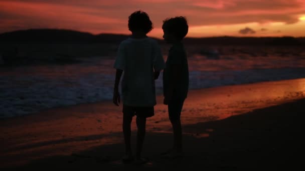 日没のシルエットで海の子供たち 子供たちは太陽に手を差し伸べる キッズドリームコンセプト — ストック動画