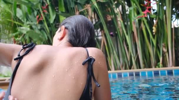 Πίσω Όψη Της Νεαρής Γυναίκας Χαλαρώνοντας Στην Πισίνα — Αρχείο Βίντεο