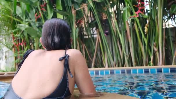 プールでリラックスした若い女性のバックビュー — ストック動画