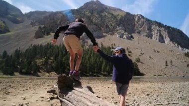 Ağaç kütüğünde yürüyen kardeşiyle oğlanın yakın görüntüsü