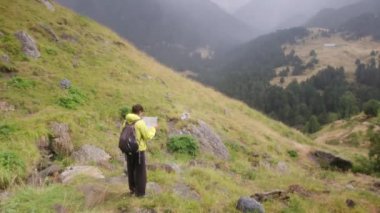 Orman dağında tek başına bir kadın haritayla kendini yönlendiriyor ve bir yolunu buluyor.
