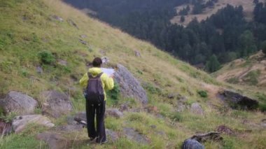 Orman dağında tek başına bir kadın haritayla kendini yönlendiriyor ve bir yolunu buluyor.