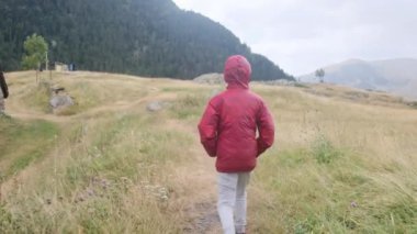 Küçük bir çocuğun yaz boyunca ulusal bir parkta yürüyüşünün arkası.