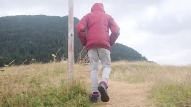 Küçük bir çocuğun yaz boyunca ulusal bir parkta yürüyüşünün arkası.