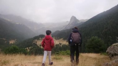 Anne ve oğulları yaz boyunca ulusal parkta yürüyorlar.