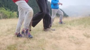 Dağlarda yürüyüş yapan çocuklu genç bir kadın.