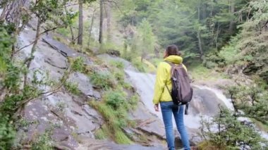Verdant Forest Wonderland 'daki Şelaleler' in Huzur Yolculuğu. Büyüleyici bir ormanda, şelalenin huzur verici sesleri eşliğinde bir kadının huzur dolu yolculuğuna katılın.
