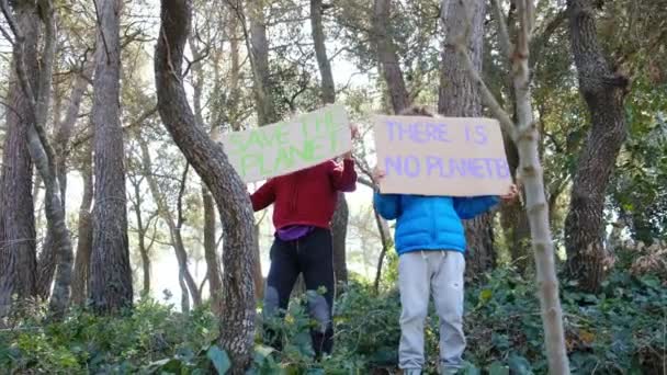 地球を救うボランティアの子供たち 森林公園にプラスチック製の旗を持っていない少年活動家 地球温暖化と戦い ゴミをリサイクルする エコロジー環境問題 — ストック動画