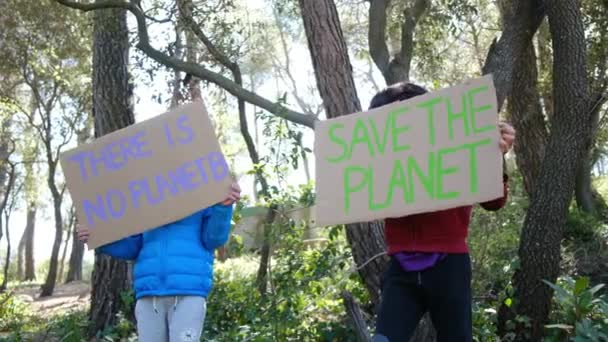 地球を救うボランティアの子供たち 森林公園にプラスチック製の旗を持っていない少年活動家 地球温暖化と戦い ゴミをリサイクルする エコロジー環境問題 — ストック動画