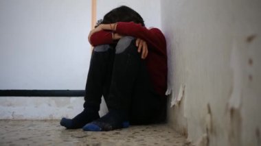 Aile içi şiddet. Yüzünde morluklar ve sıyrıklar olan küçük çocuk köşede ağlarken cezalandırıldı. Aile içi şiddet konsepti. Çocuk cezalandırılır ve korkudan dövülür.