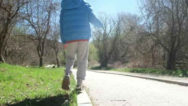 Fiú Végigsétál Járdán Megtartja Egyensúlyát — Stock videók
